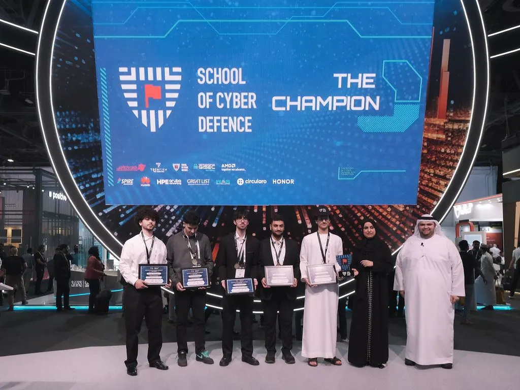Champion team receiving their awards on stage at School of Cyber Defence